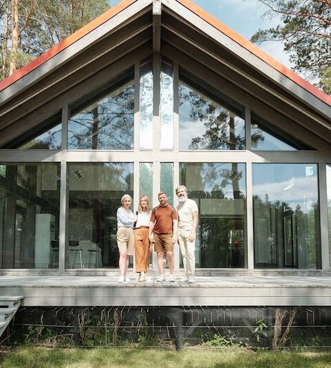 En familj som står på altanen till et fritidshus